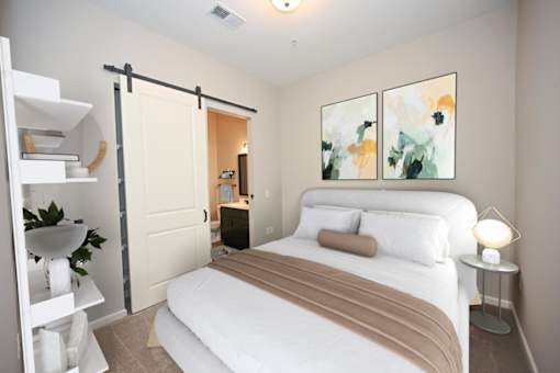 A bedroom with a bed, nightstand, and a painting on the wall at Essex, Columbus, OH