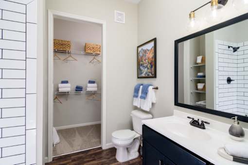 a bathroom with a white toilet next to a white sink with a mirror above it at Essex, Columbus, OH