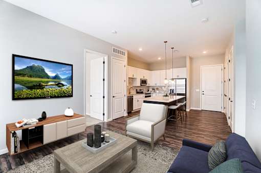 a living room with a couch and a table in front of a kitchen at Essex, Columbus