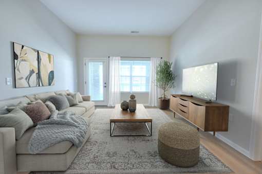 A living room with a grey couch, a coffee table, and a television.