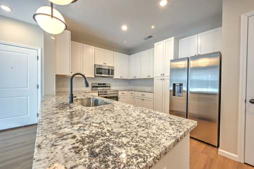 A kitchen with granite countertops and stainless steel appliances.