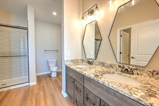 A bathroom with a marble countertop and a large mirror.
