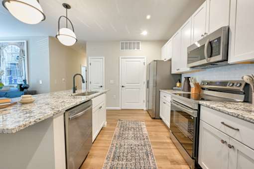 A kitchen with granite countertops and stainless steel appliances.