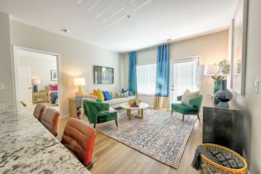A living room with a green couch and a rug.