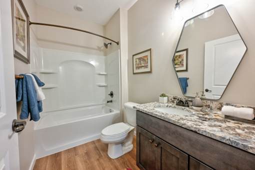 A bathroom with a white toilet and a marble counter top.