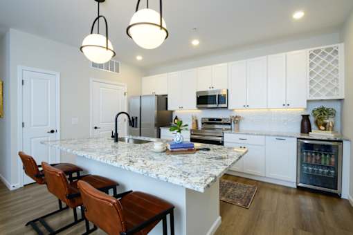 A kitchen with a marble countertop and white cabinets.