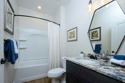 A bathroom with a white tub, toilet, and sink.
