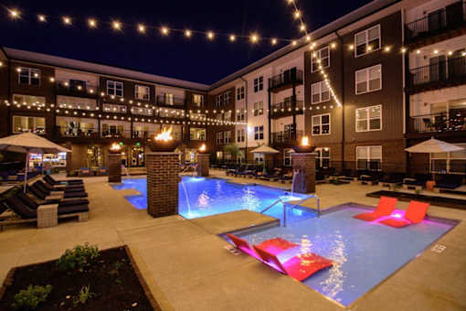 the pool is lit up at night at the apartments at Taylor House Apartments, Ohio
