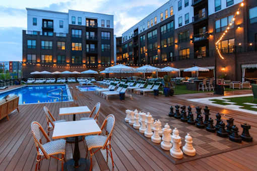 A giant chess board is set up on a wooden deck.