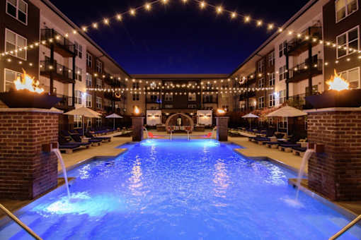 A pool lit up with blue lights at night.