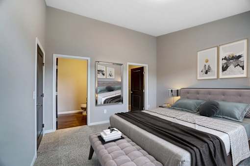 a bedroom with a large bed and a mirrorat Taylor House Apartments, Columbus, Ohio