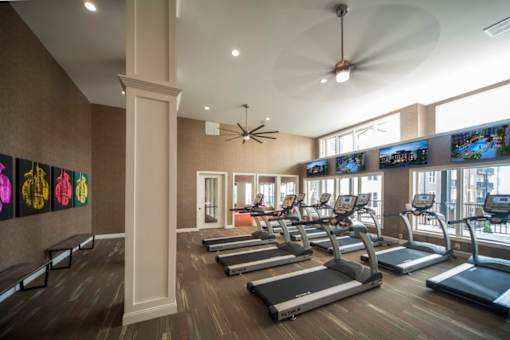 a gym with treadmills and televisions on the wall at Taylor House, Columbus, OH