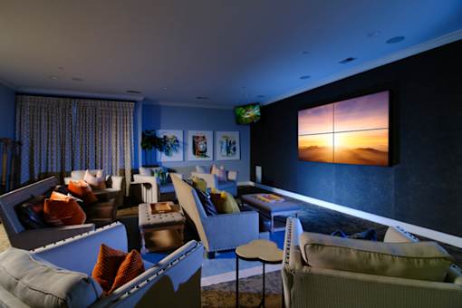 A living room with a large screen on the wall and a couch.