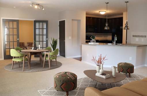 a living room and kitchen with a table and chairs