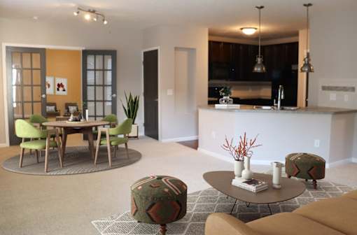 a living room and kitchen with a table and chairs
