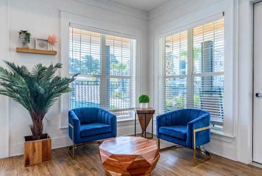 a living room with two blue chairs and a table