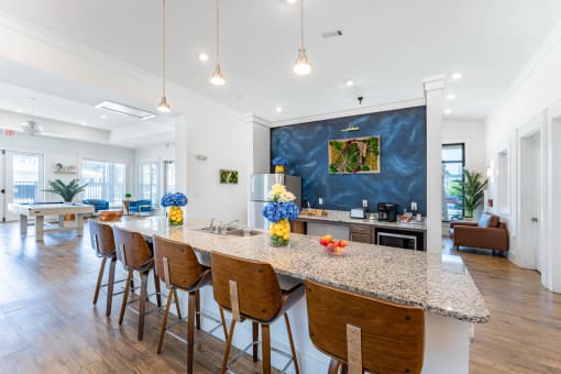 a kitchen with a marble counter top and a long island with high chairs