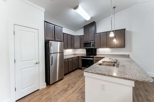 an empty kitchen with stainless steel appliances and granite counter tops
