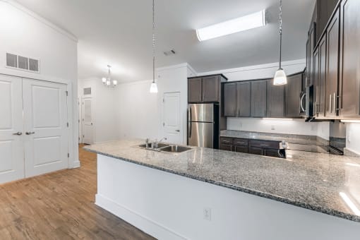 a kitchen with a granite counter top and a stainless steel refrigerator