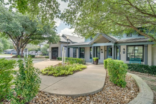 a sidewalk in front of a house with trees