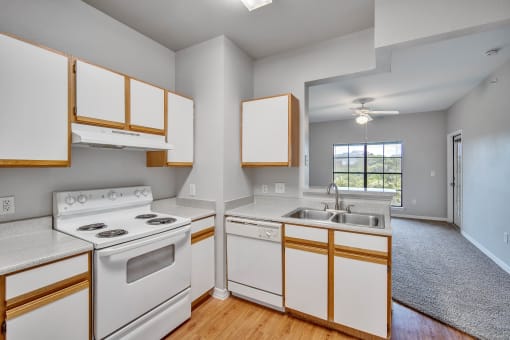 an empty kitchen with white appliances and wooden cabinets
