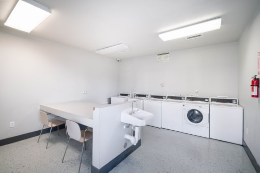 a laundry room with a table and chairs and a washing machine