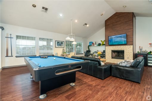 a living room with a pool table and a fireplace