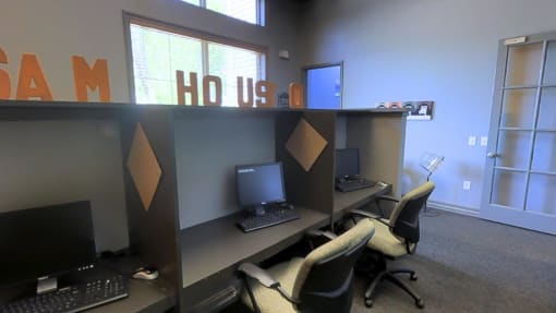 an office with two computers and two chairs