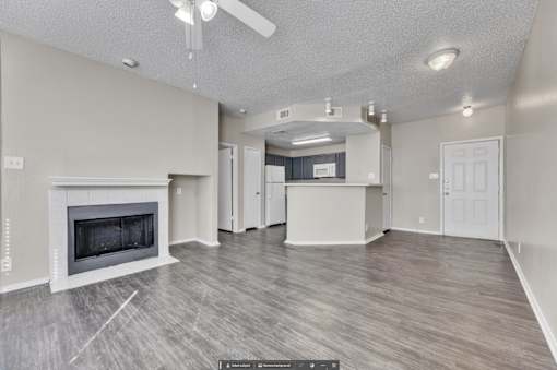 A spacious living room with a fireplace and hardwood flooring.