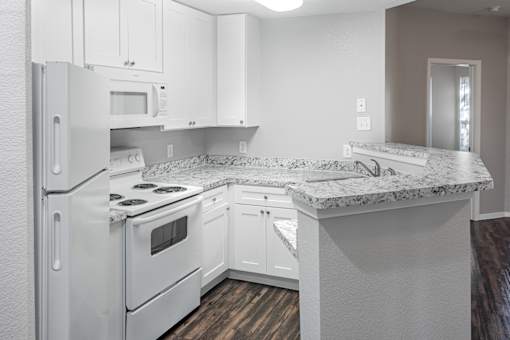 A kitchen with white appliances and cabinets.
