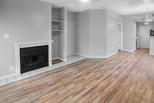 A room with a fireplace and wooden floors.