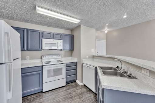 A kitchen with white appliances and a white refrigerator.