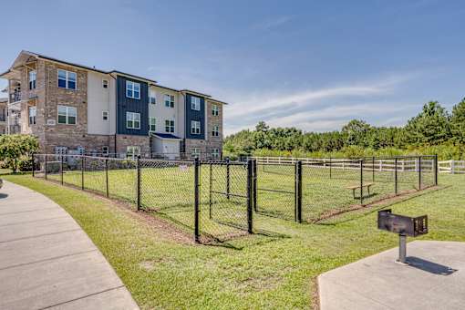 Apartment complex with a fenced in yard.