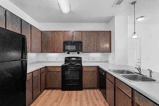 A kitchen with black appliances and wooden cabinets.