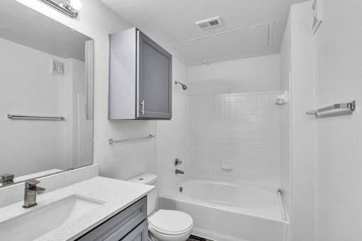 A bathroom with a toilet, sink, and bathtub.