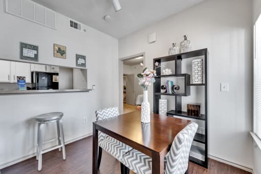 a dining room with a wooden table and chairs and a kitchen with a counter top