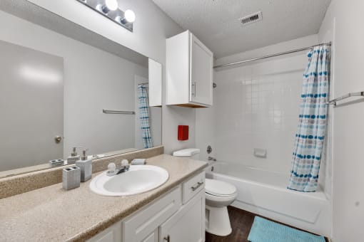 a bathroom with a sink toilet and shower