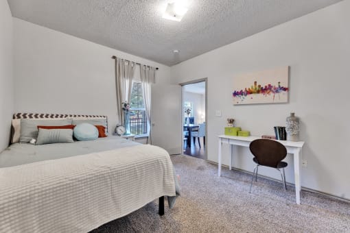 a bedroom with a bed and a desk with a chair