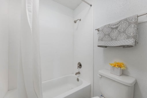 white bathroom with a shower at Tall Timbers Apartments, Houston Texas