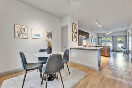 a dining area with a round table and chairs and a kitchen with a sink