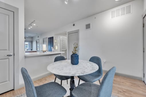 a dining room with a marble table and blue chairs