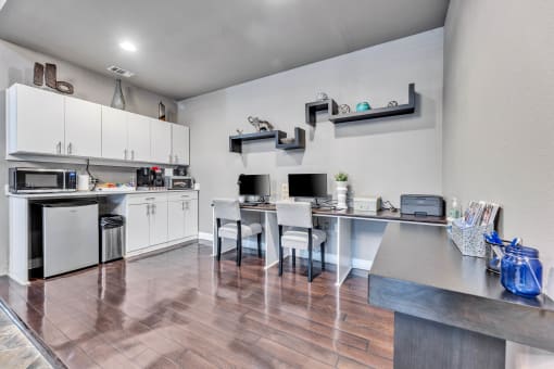 a kitchen with white cabinets and stainless steel appliances and a table with chairs at Waters at Elm Creek, San Antonio, Texas