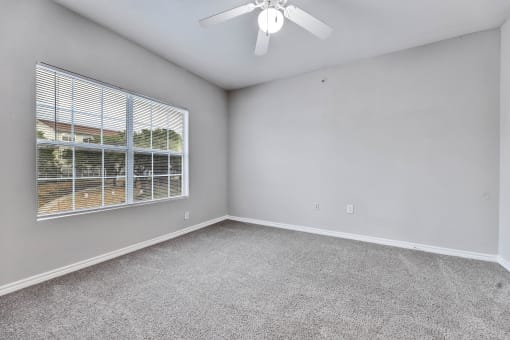 A room with a ceiling fan and a window with blinds at Waters at Elm Creek, San Antonio, Texas
