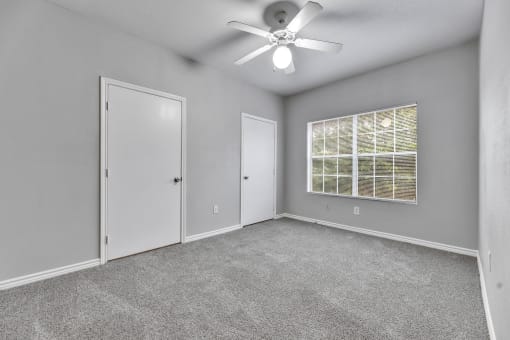 an empty room with a ceiling fan and a window at Waters at Elm Creek, San Antonio, TX 78230