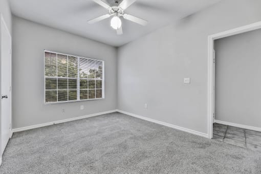 A room with a ceiling fan and a window with blinds at Waters at Elm Creek, San Antonio, TX