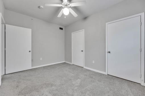 A room with a ceiling fan and three doors at Waters at Elm Creek, Texas