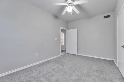 the living room of an empty house with a ceiling fan at Waters at Elm Creek, San Antonio