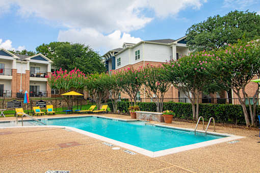 A swimming pool surrounded by a fence and trees.