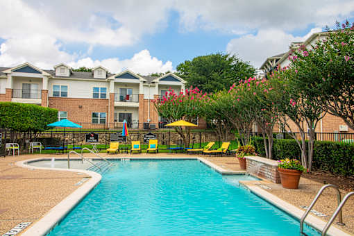 A swimming pool surrounded by yellow chairs and umbrellas.