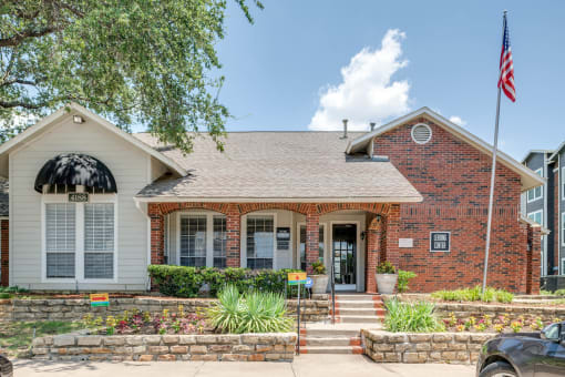 the front of a brick house with an flag on the side of it